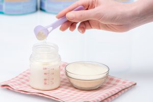 Preparation of mixture baby feeding. Close up of preparing baby formula. Preparing baby's bottle. Artificial feeding of babies